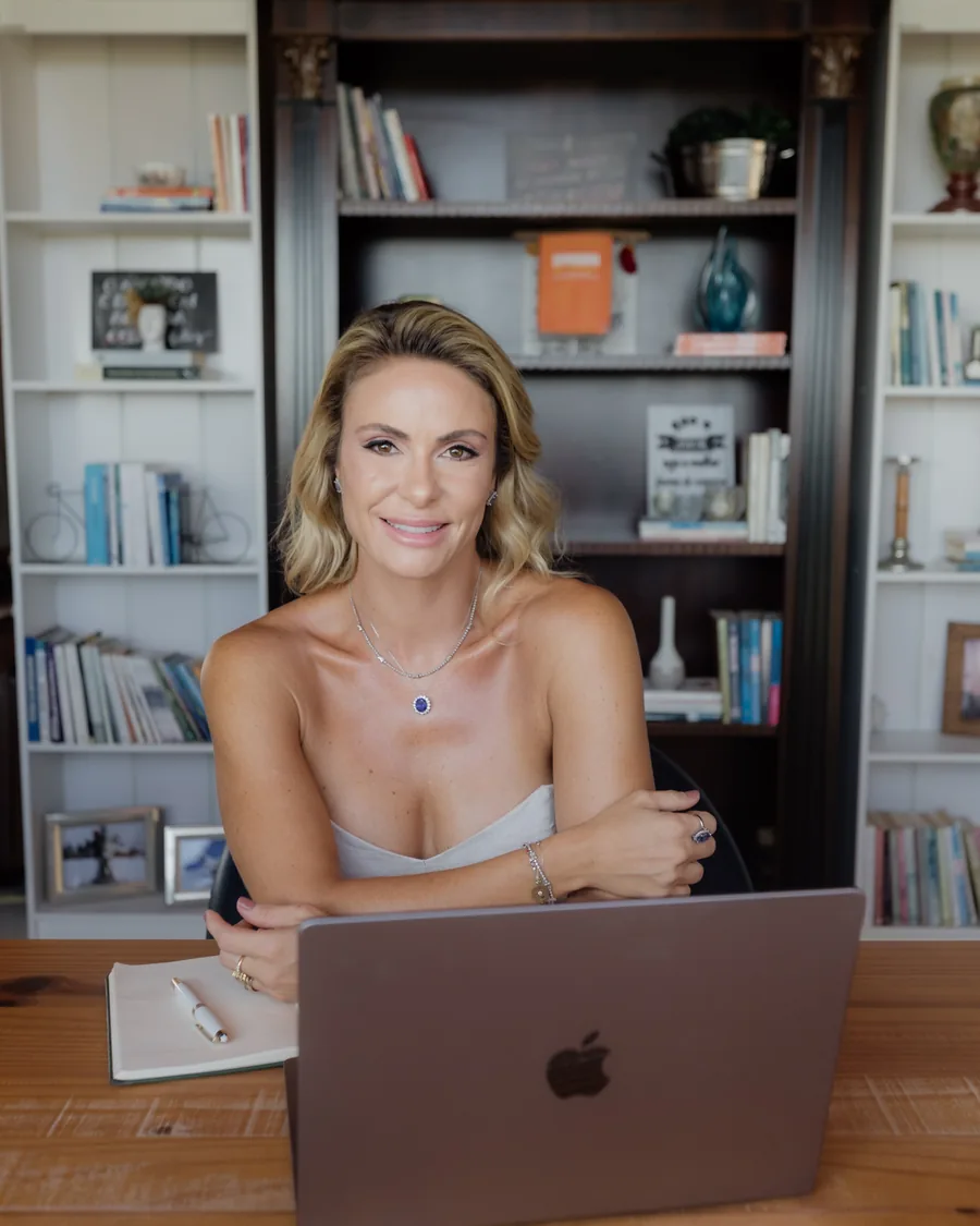Maria Flávia sentada em seu escritório, sorrindo